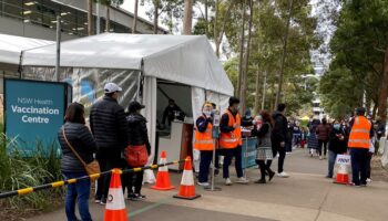 People-wait-in-line-outside-a-coronavirus-disease-COVID-19-vaccination-centre-at-Sydney-Olympic-Park-in-Sydney