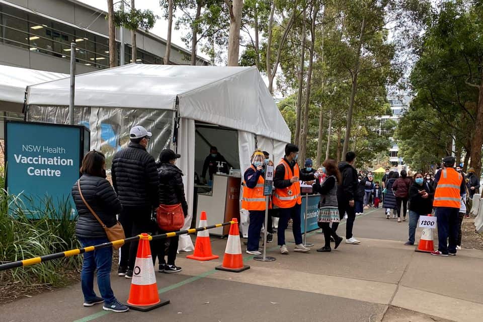 People wait in line outside a coronavirus disease (COVID-19) vaccination centre at Sydney Olympic Park in Sydney